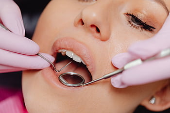 Close-up of a woman's dental checkup with a dentist using tools in a clinic. HD wallpaper