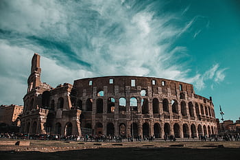 Stunning view of the Colosseum in Rome showcasing its ancient architecture and historic grandeur. HD wallpaper