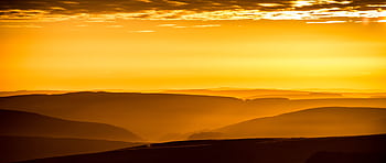 Breathtaking golden sunrise over rolling hills, capturing serene beauty and vibrant colors. HD wallpaper