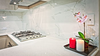 Stylish kitchen interior featuring decorative candles and orchids on a countertop. HD wallpaper