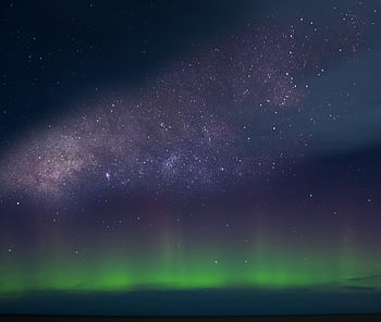 Marvel at the breathtaking view of the aurora borealis under the Milky Way in a starry night sky. HD wallpaper