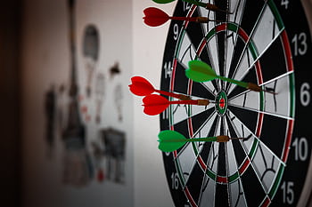Close-up of a dartboard with multiple darts hitting the target, emphasizing precision and focus. HD wallpaper
