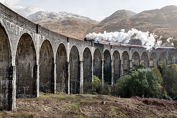 Scenic view of a steam train crossing the Glenfinnan Viaduct in the Scottish Highlands. HD wallpaper