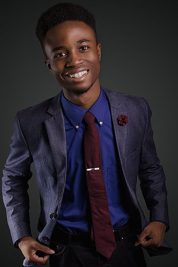 Portrait of a smiling young black man in a stylish suit with a confident pose. HD phone wallpaper