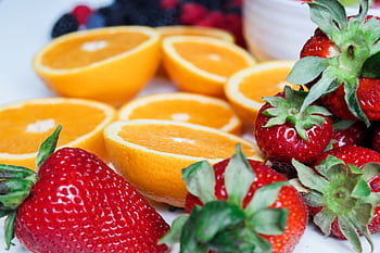 Close-up of sliced oranges and strawberries, showcasing vibrant colors and fresh appeal. HD wallpaper