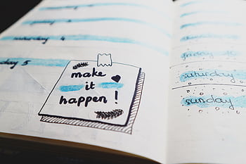 Close-up view of a planner page with motivational text and colorful designs. HD wallpaper