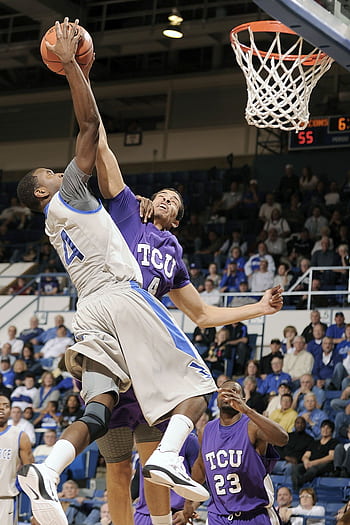 Players from two college teams compete fiercely for a basket during a lively game. HD phone wallpaper
