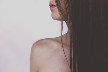 Close-up portrait focusing on a woman's elegant shoulder and long, silky hair against a soft background. HD wallpaper