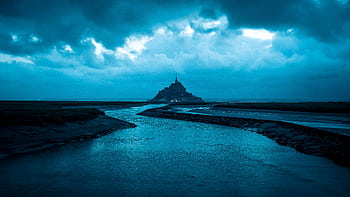 A moody, twilight view of Mont Saint-Michel with dramatic clouds. HD wallpaper