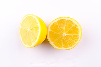 Close-up of fresh, juicy lemon halves on a clean white background. HD wallpaper