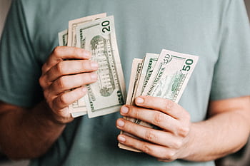 Close-up of a person counting US dollar bills indoors. Financial concept. HD wallpaper
