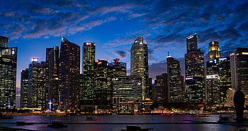 Spectacular view of Singapore's skyline with illuminated skyscrapers against a twilight sky. HD wallpaper