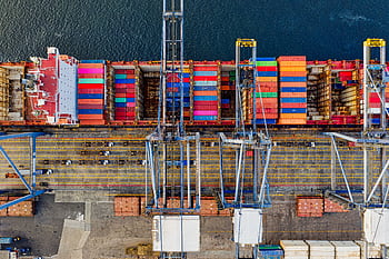 Aerial view of colorful cargo containers at a bustling port in Jakarta, Indonesia. HD wallpaper