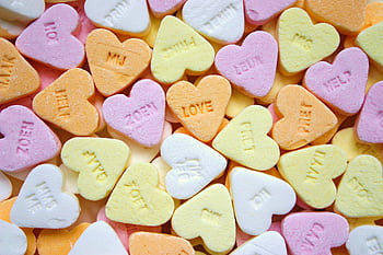 Colorful heart-shaped candies with embossed love messages, perfect for romance themes. HD wallpaper