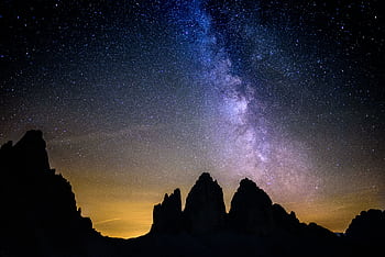A breathtaking view of the Milky Way over the rugged peaks of the Dolomites in Italy. HD wallpaper