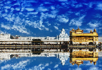 The Golden Temple, Harmandir Sahib, in Amritsar beautifully reflected in water with a vivid blue sky. HD wallpaper