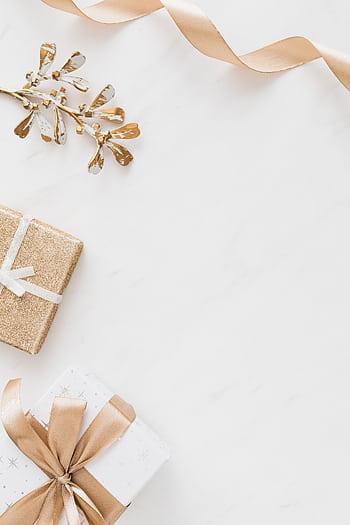 Stylish flat lay of Christmas gifts with golden accents on a white background, perfect for holiday themes. HD phone wallpaper
