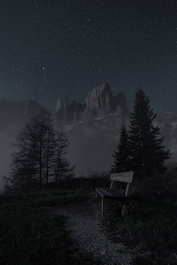 A tranquil scene featuring a bench under a starry night sky with mountains in the background. HD phone wallpaper