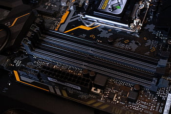 Detailed view of a computer motherboard showcasing RAM slots and electronic components. HD wallpaper