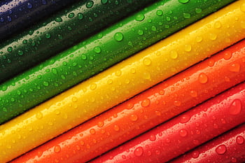 Close-up of colorful pencils with water droplets, displaying vibrant hues. HD wallpaper