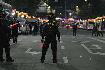 Police officers maintaining order during a night street patrol, ensuring public safety. HD wallpaper