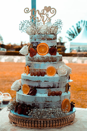 Four-tier rustic wedding cake adorned with oranges and flowers, perfect for outdoor celebrations. HD phone wallpaper