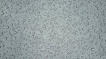 Detailed macro capturing various water droplets on a glass surface, showcasing texture. HD wallpaper