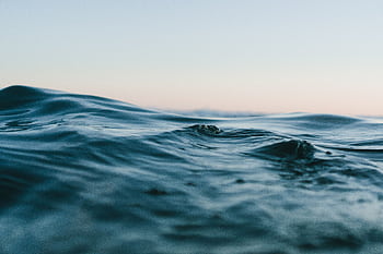 Tranquil ocean waves under a soft sunset sky, perfect for backgrounds. HD wallpaper