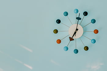 Close-up of a colorful modern wall clock on a blue background. HD wallpaper