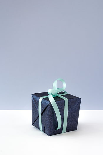 A sophisticated gift box wrapped in blue paper with a delicate ribbon, perfect for celebrations and surprises. HD phone wallpaper