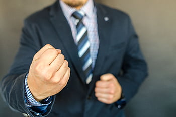 Close-up of a businessman in a suit showing determination with a fist. HD wallpaper