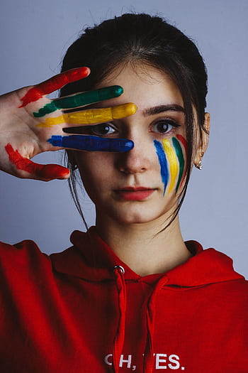 Woman with colorful face paint and hand art poses in studio. HD phone wallpaper