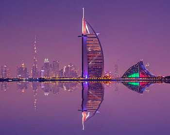 Captivating night scene showcasing Burj Al Arab and Dubai skyline reflections. HD wallpaper