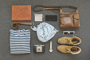 Vintage travel essentials flat lay with leather bags, shoes, camera, and clothing. HD wallpaper
