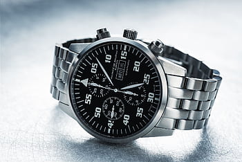 Close-up shot of a sleek stainless steel chronograph watch with black dial. HD wallpaper