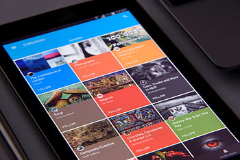 Close-up of a tablet displaying diverse content collections in a grid format. HD wallpaper