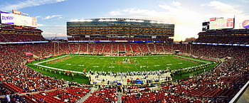 A stunning panoramic shot of Levi's Stadium in Santa Clara during a packed football game at sunset. HD wallpaper