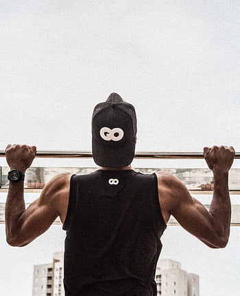 Back view of a man in gym attire doing pull-ups outdoors, demonstrating strength and fitness. HD phone wallpaper