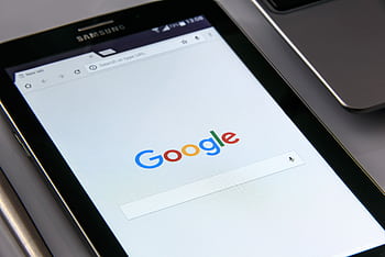 Close-up of a tablet displaying Google's search screen, emphasizing technology and internet browsing. HD wallpaper