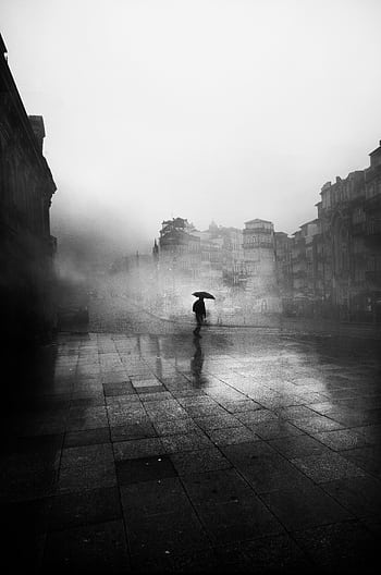 A lone figure with an umbrella in a foggy city, creating a moody, atmospheric scene. HD phone wallpaper