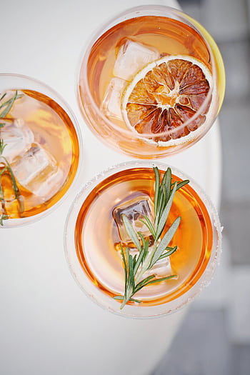 Top view of three citrus and rosemary cocktails with ice and garnish on a summer day. HD phone wallpaper
