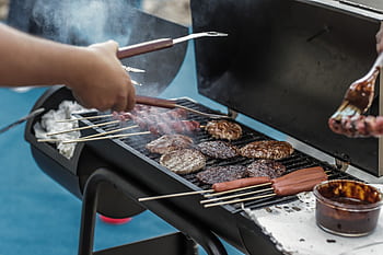 Delicious meats and sausages grilling on a barbecue outside, perfect for a summer picnic. HD wallpaper