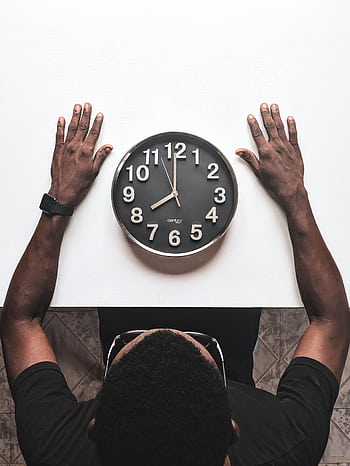 High angle view of a man with an apple watch observing a clock on a white table. HD phone wallpaper
