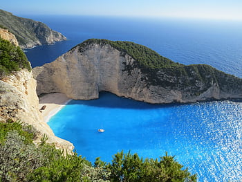 A breathtaking view of Navagio Beach with azure waters surrounded by cliffs in Greece. HD wallpaper