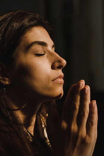 A woman with eyes closed in prayer, conveying peace and introspection. HD phone wallpaper
