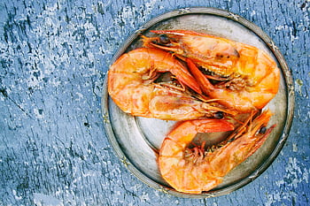 Top view of cooked shrimps on a metal plate on rustic surface. Perfect for seafood lovers. HD wallpaper