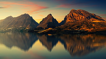 Captivating mountain scenery reflected on a tranquil lake at sunset. HD wallpaper
