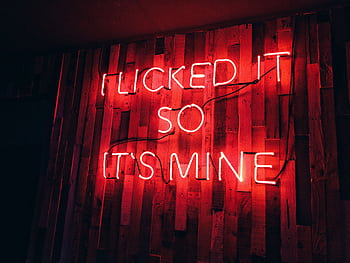 Vibrant red neon sign displays playful text on a rustic wooden wall, perfect for modern decor themes. HD wallpaper