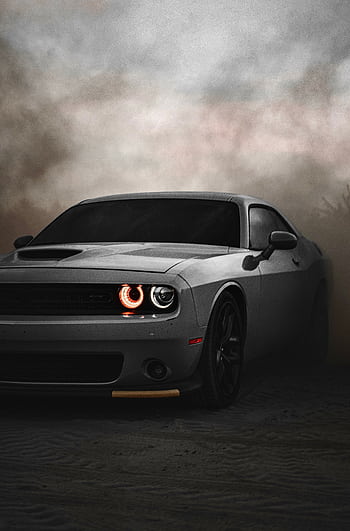 Dodge Challenger sports car in a dramatic, cloudy outdoor setting. Ideal for automotive enthusiasts. HD phone wallpaper
