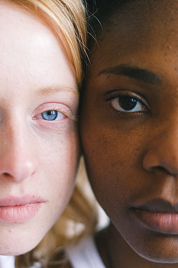 Intimate close-up of two women of different ethnicities showcasing diversity. HD phone wallpaper